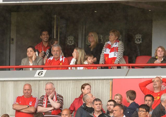 A smiling Luis Suarez (back left) attends Liverpool's opening fixture of the Premier League season. The Uruguayan striker is serving the fifth game of a 10-match ban for biting Branislav Ivanovic in a match against Chelsea last April. Suarez's future at Liverpool is in doubt following an acrimonious summer in which the striker has agitated for a move away from Merseyside. Liverpool insist the player is not for sale.