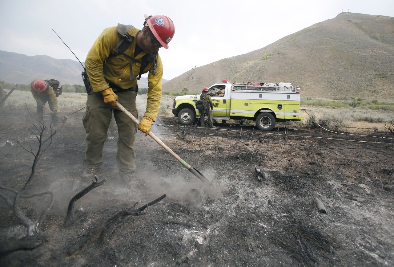 Firefighters clear an area burned by the Beaver Creek Fire on August 17. Approximately 1,200 firefighters are working the blaze, with the help of helicopters, bulldozers and conventional engines.