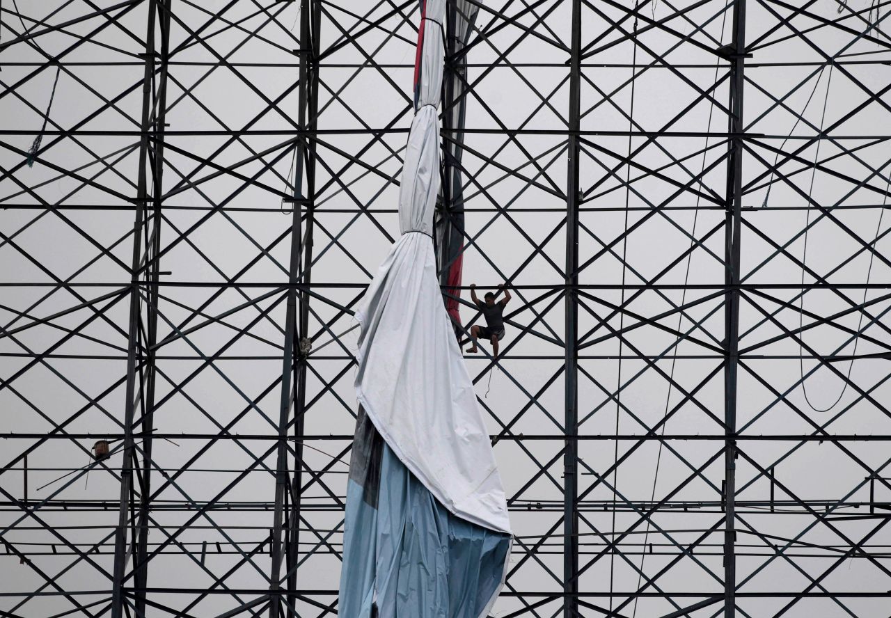 A Filipino worker brings down a giant billboard to prevent it from being blown by strong winds in Quezon City on August 18. Tropical Storm Maring continued to move east away from northern Philippines, but rain continued over parts of the country.