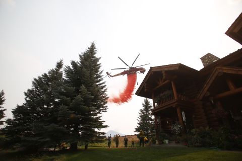 A helicopter drops fire retardant to protect homes outside Ketchum, Idaho, from the Beaver Creek Fire on Sunday, August 18.