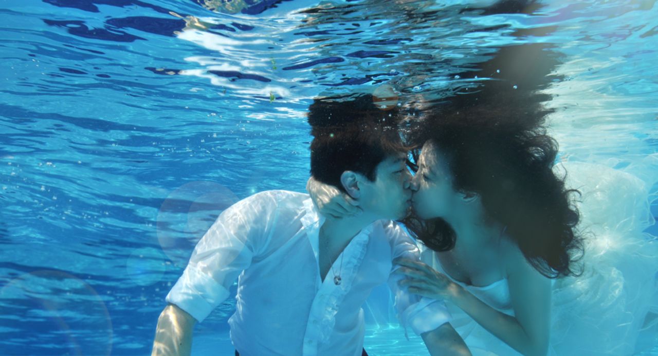 Kenny Tang and Olivia Kok wanted their engagement photos to reflect their active, sporty lifestyle. Over three days at a hotel swimming pool, the diving enthusiasts attempted to capture images of their love underwater. 