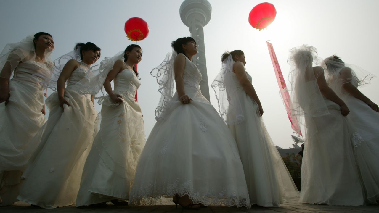 Brides line up during a collective wedding ceremony for 100 migrant worker couples  in Nanjing China. 