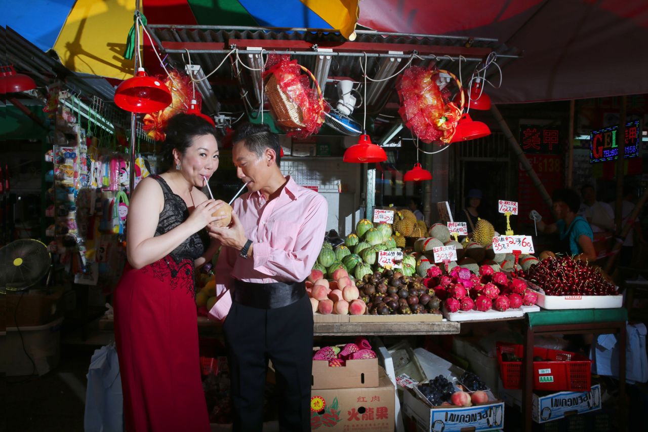 In another shot, the couple pose near a fruit stall in Hong Kong.