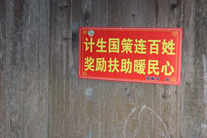 Propaganda slogans are commonplace in Chinese villages to encourage people to comply with government policies. This one reads: State family planning policy connects everyone. Rewards and subsidies warm the heart of the people."