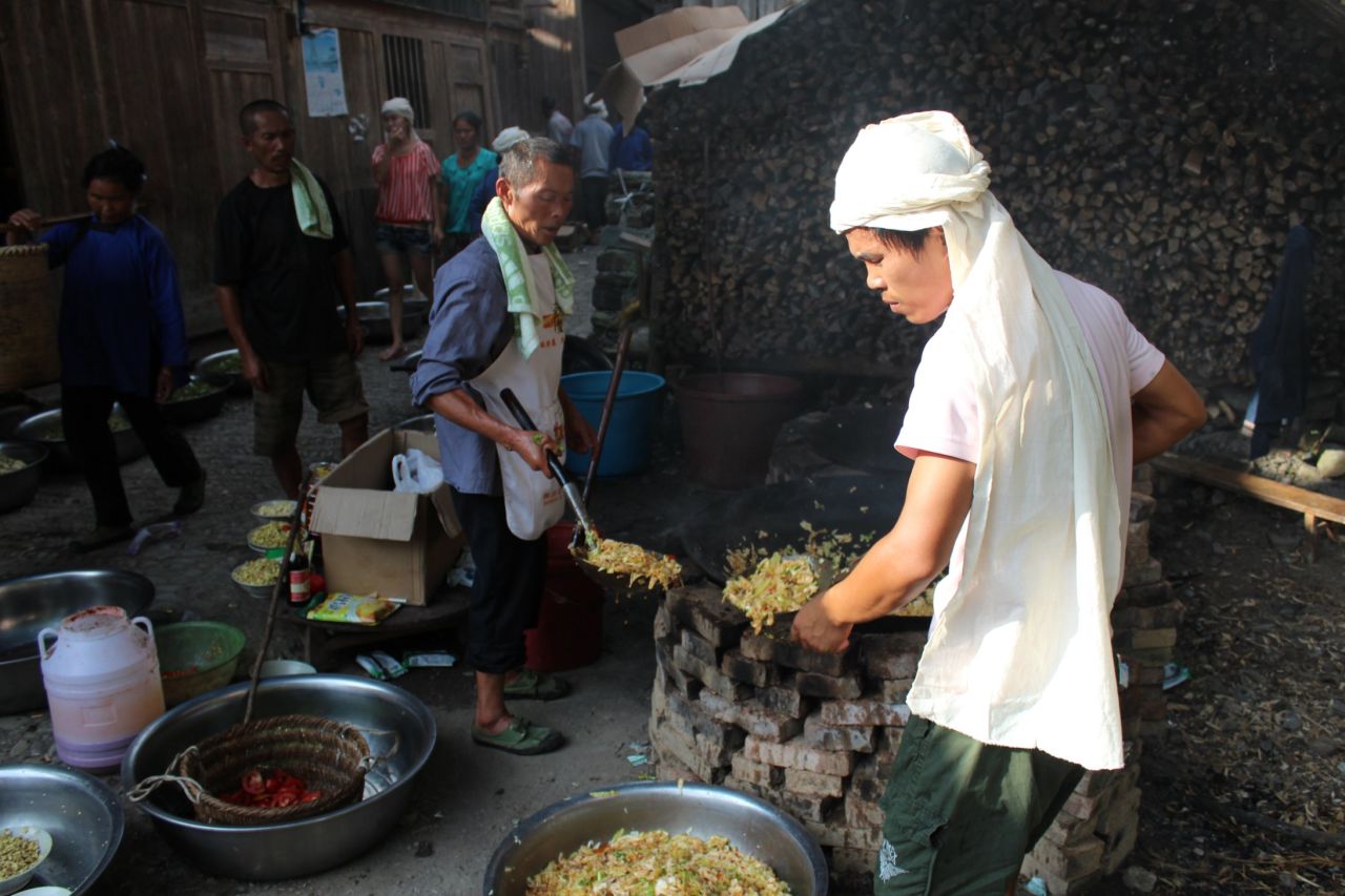 The village marks major events like births and deaths with communal meals cooked in giant woks.