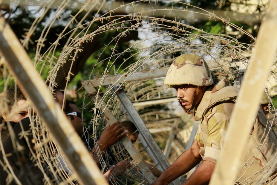 A soldier sets up barbed wire in anticipation of protesters outside the constitutional court in Cairo on Sunday, August 18, 2013. During the previous week about 900 people -- security forces as well as citizens -- had been killed. Deaths occurred when the military used force to clear supporters of ousted president Mohamed Morsy from two sit-in sites in Cairo, and violence raged after Morsy supporters staged demonstrations.