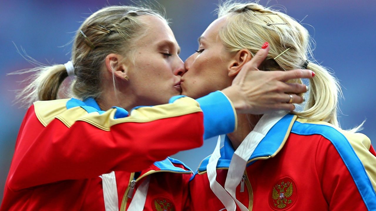 Tatyana Firova and Kseniya Ryzhova of Russia kiss on the podium during the medal ceremony. 