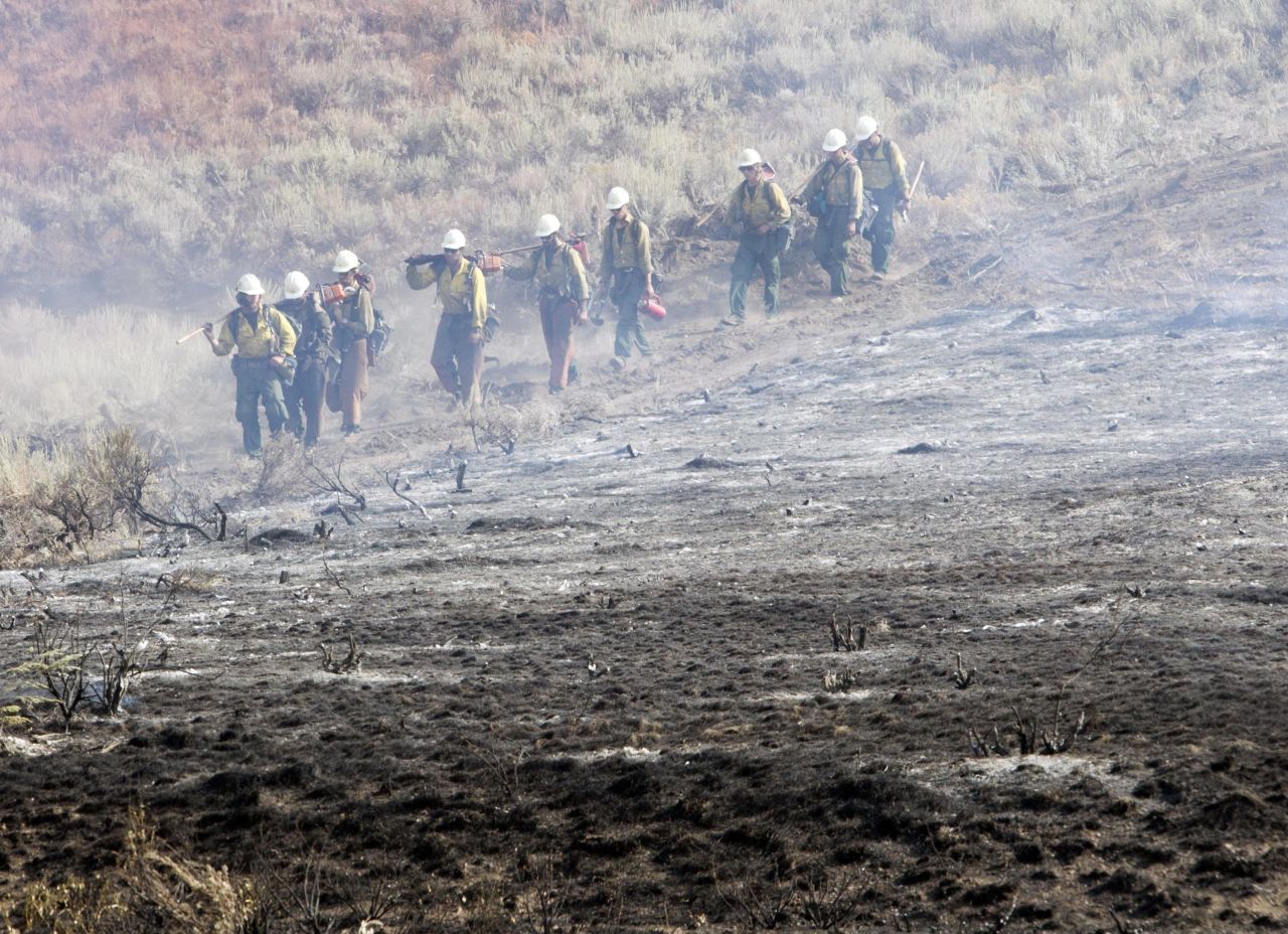 A firefighting team walks along a fire line near homes on Croy Road and the Rotorun ski hill west of Hailey, Idaho, on Saturday, August 17. A wildfire raging across the central mountains of Idaho forced the evacuation of 200 homes in the tourist town of Hailey as firefighters lost ground against a blaze threatening the nearby international ski destination of Sun Valley.