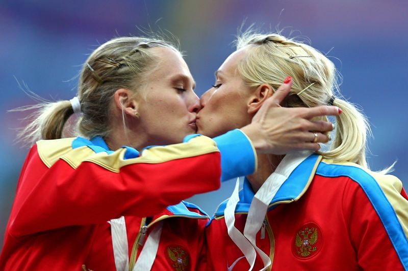 Russian runners kiss on the winners podium at competition in Moscow picture