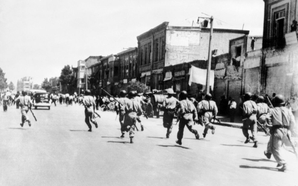 Soldiers chase rioters during civil unrest in Tehran. Massive protests broke out across the nation in 1953.