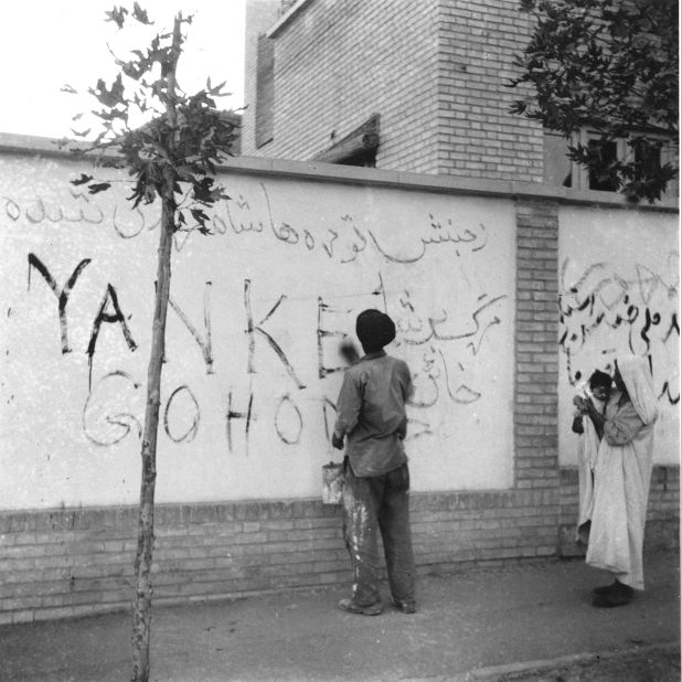 A resident washes "Yankee Go Home" graffiti off a wall in Tehran on August 21, 1953. Zahedi ordered a clean-up after the coup.