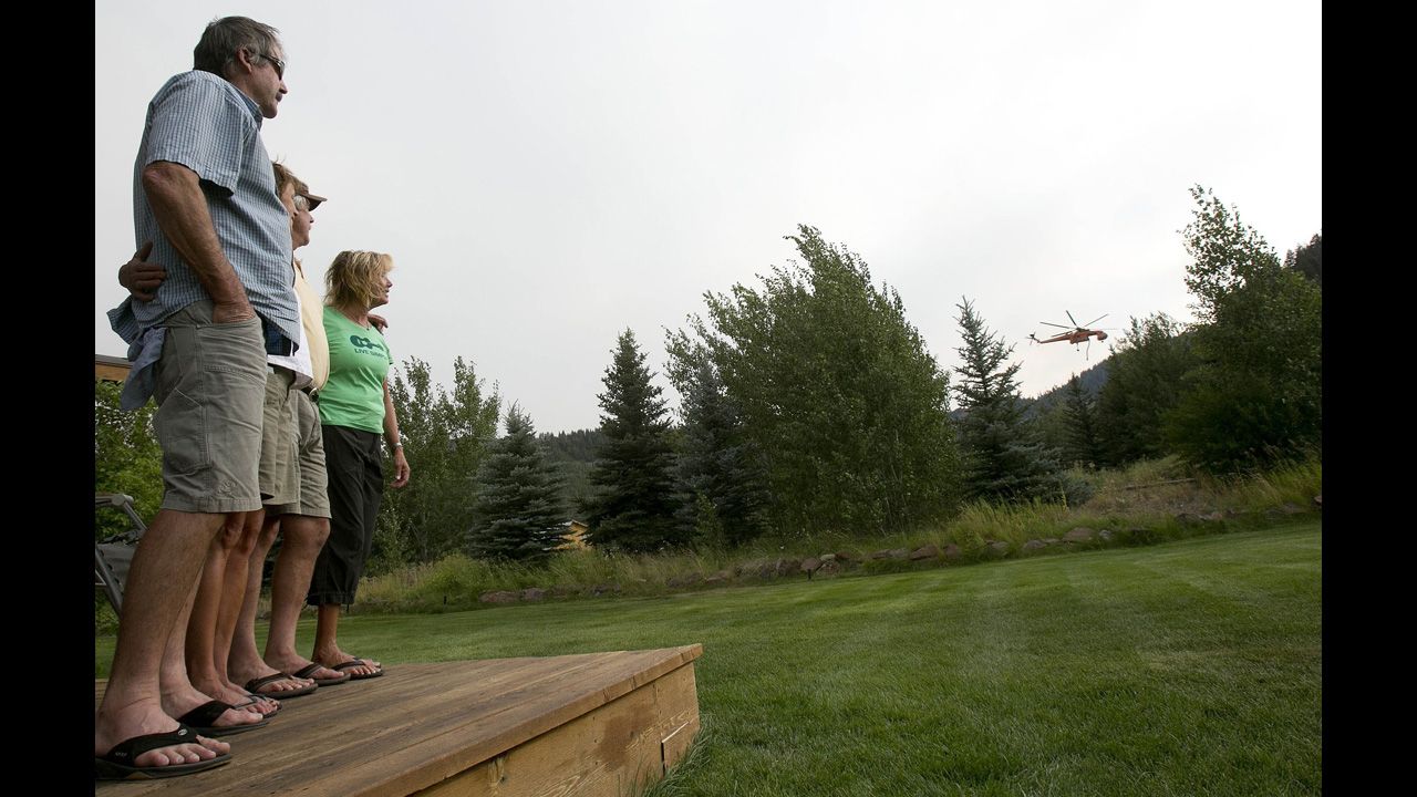 Charlie Pomeroy, left, Stacey Ward, Rusty Hollinger and Suzy Hayes watch a sky crane fill up on fire retardant on August 19.