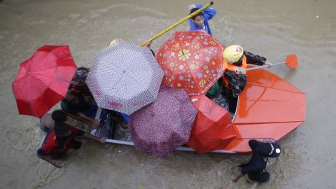Members of the Philippine army paddle a boat with residents as they enforce an evacuation in Marikina City on August 20.