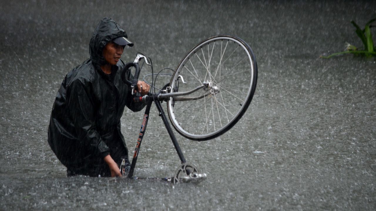 A man guides his bike through flood waters that submerged parts of the financial district of Makati on August 20.