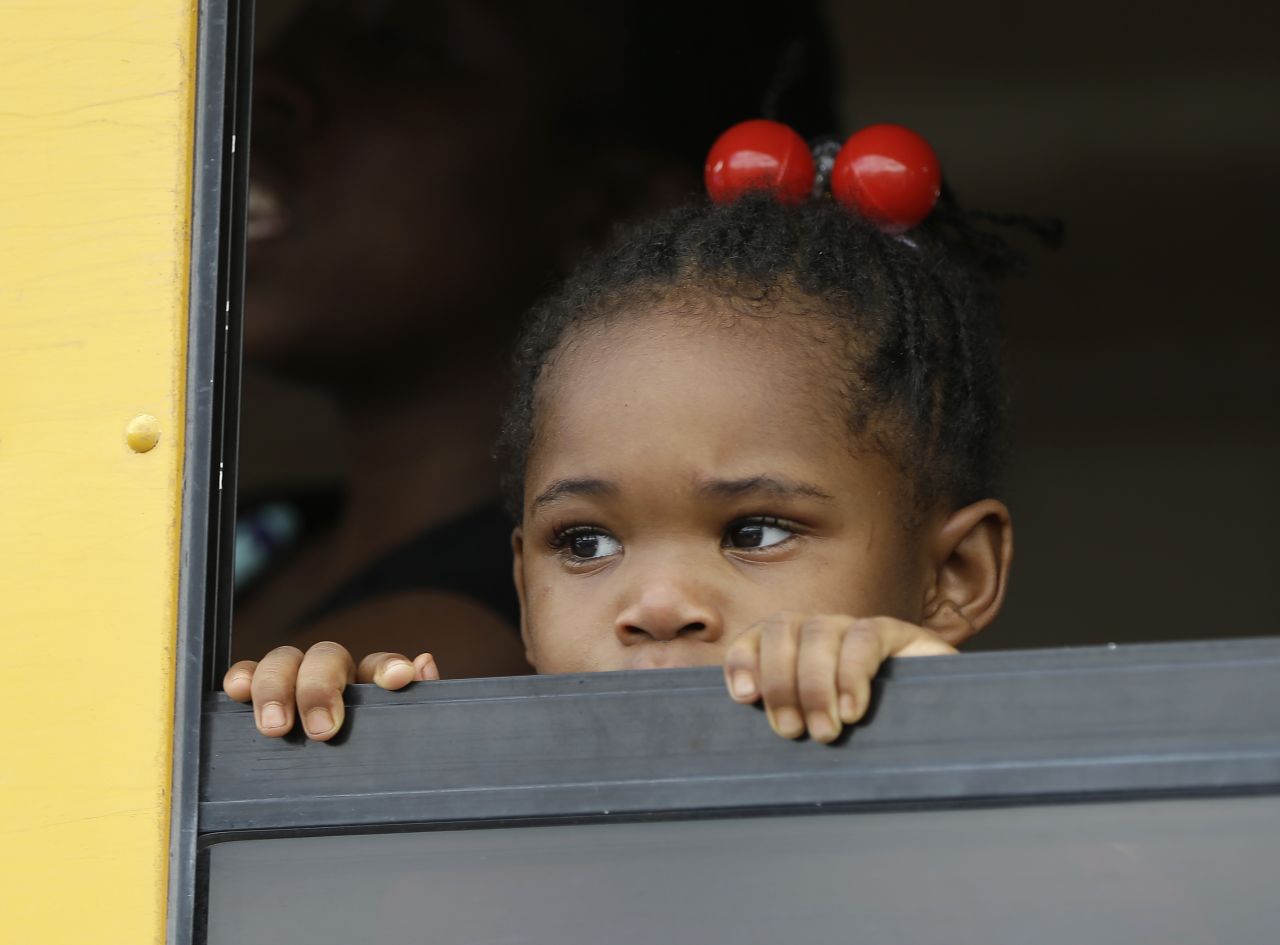 A child peers out the window of a school bus as the children are returned to their parents at a nearby shopping center Tuesday afternoon.
