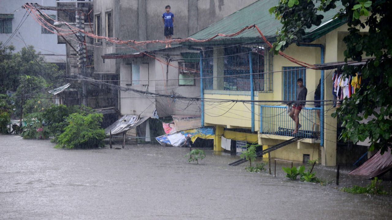 Men watch flooding from their homes in Manila on August 20.