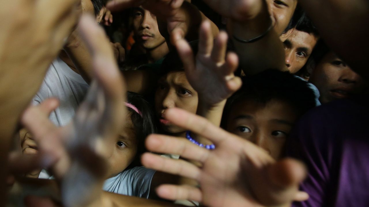Filipinos displaced by flooding reach for relief goods in Las Pinas on Wednesday, August 21. Tens of thousands of Filipinos have been forced from their homes and at least seven have died due to heavy rains and flooding.