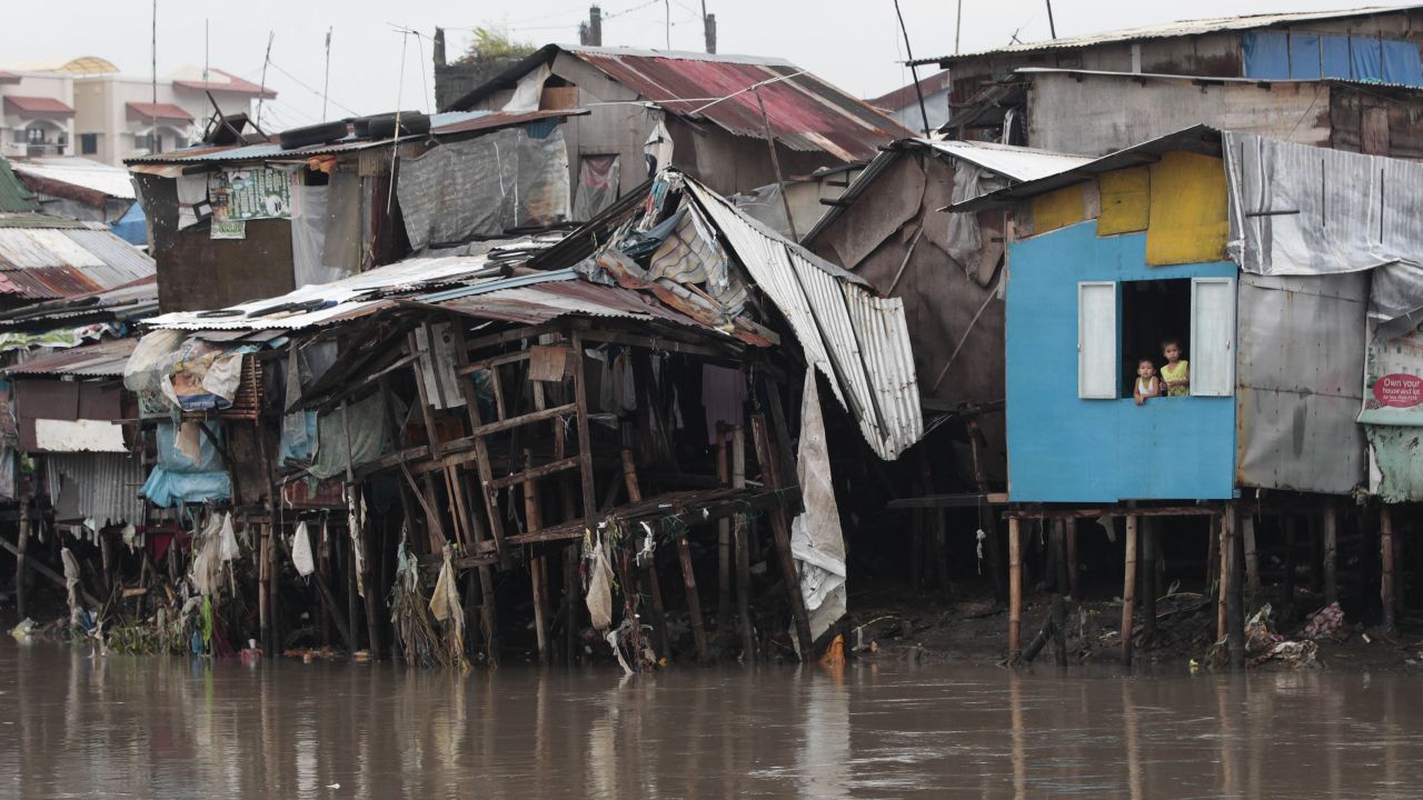 Boys looks out from their house after days of torrential rains along a waterway in Las Pinas on August 21.