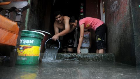 People bail water from their house in Noveleta on August 21.