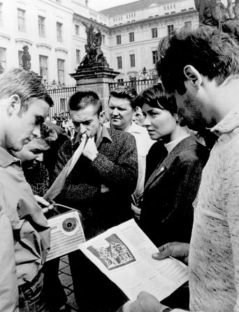 People listen to the radio for news about the invasion and the confrontations between demonstrators. The radio broadcast was cut off a few hours into the invasion.