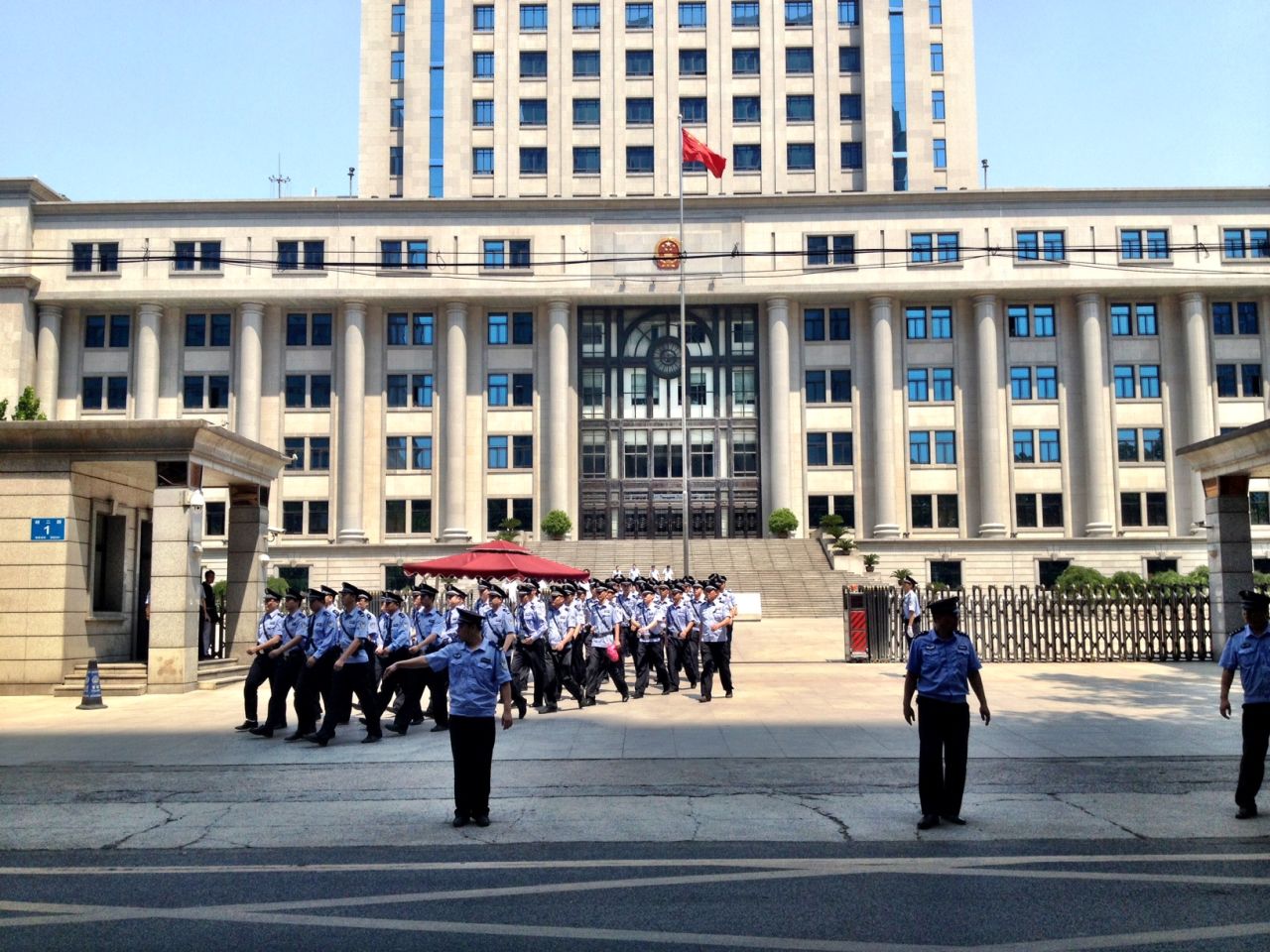 Police march outside the courthouse in Jinan on August 21.