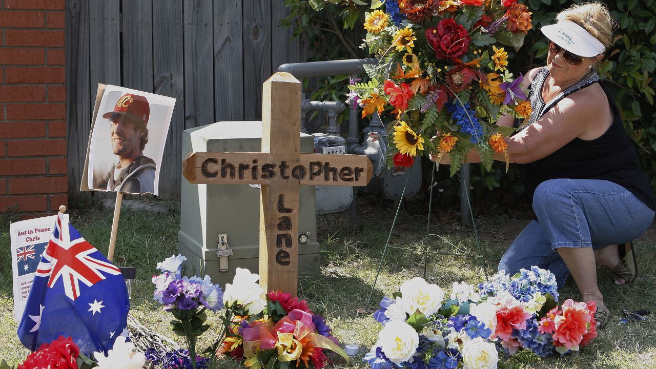 Sherrie Shannon places flowers at a memorial in Duncan, Oklahoma, on August 21 at the scene where Lane was found dead.