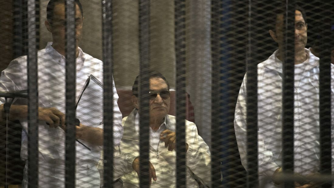 Mubarak and his sons Gamal, left, and Alaa are seen behind the defendants' cage during their retrial at the Police Academy in Cairo. Mubarak was granted a retrial.