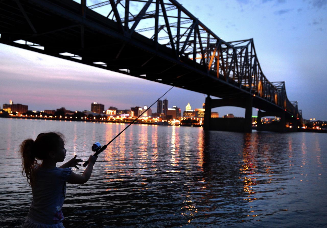 Five-year-old Makayla Dunlap casts her line into the Illinois River as she fishes for the first time in Peoria, Illinois, on August 21.