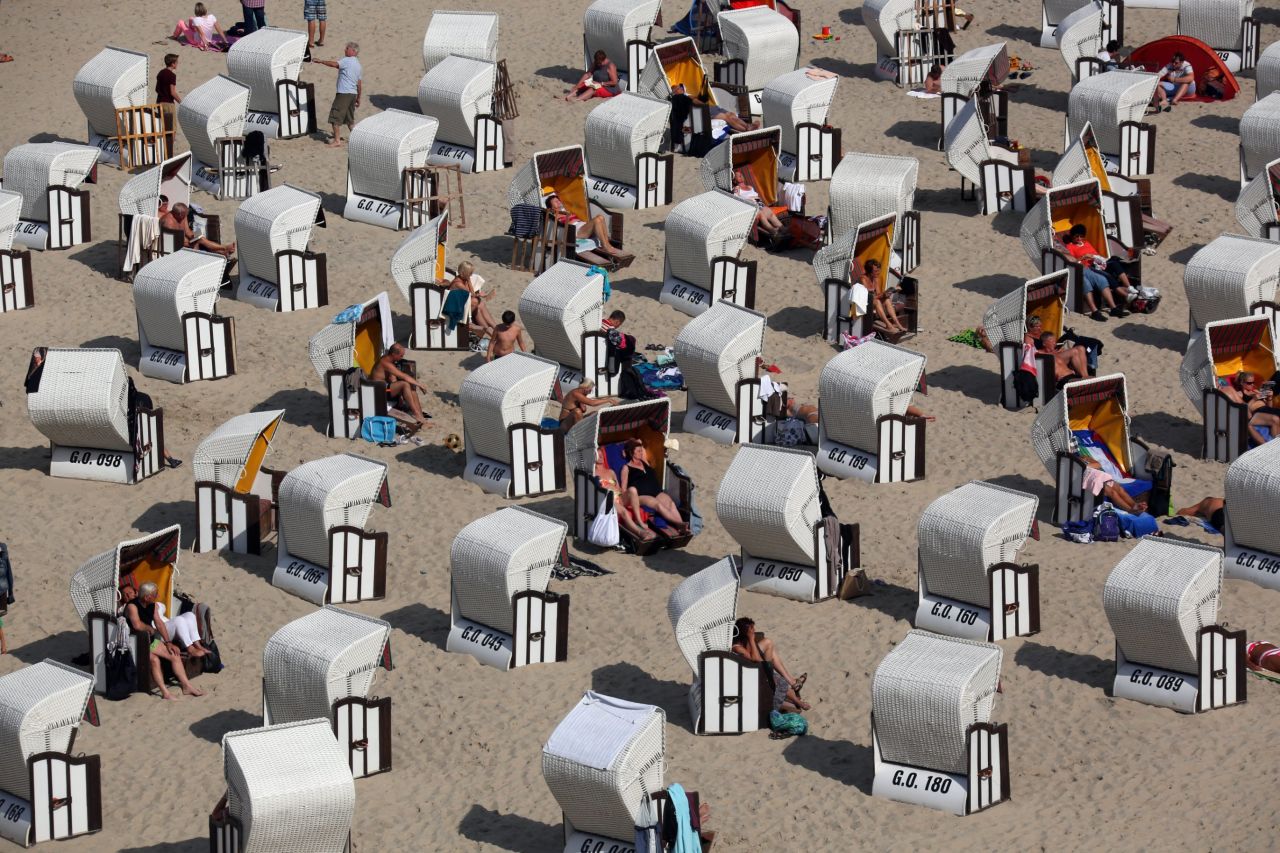 Vacationers sit on a beach on Rugen island in Sellin, Germany, on August 21. Summer returned to North Germany with temperatures above 68 degrees Fahrenheit and much sunshine.