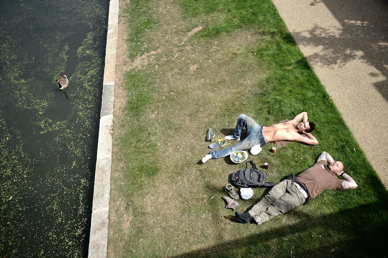 People relax in the sunshine in North London on August 21. Temperatures are expected to reach up to 80 degrees in some parts of the United Kingdom. 
