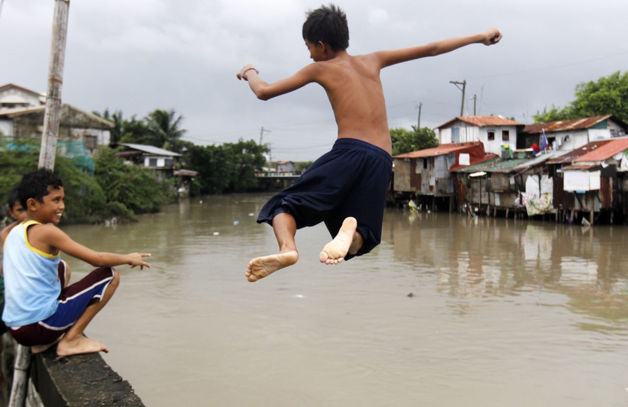 Children play in floodwaters in Las Pinas, Philippines, on August 21. Floods reaching as high as six feet swamped a wide area in the northern Philippines, including Manila, after days of heavy rains. More than 1 million people were affected, including more than 280,000 people forced to stay in emergency shelters or with family and friends, according to the National Risk Reduction and Management Council. 
