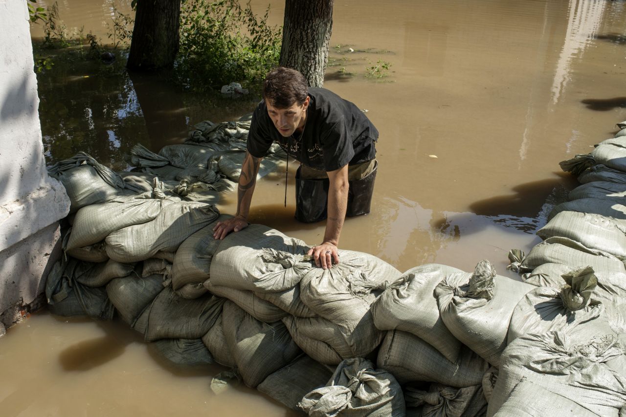 A worker sets up a dam in a flooded street, in Khabarovsk, Russia, on August 21.