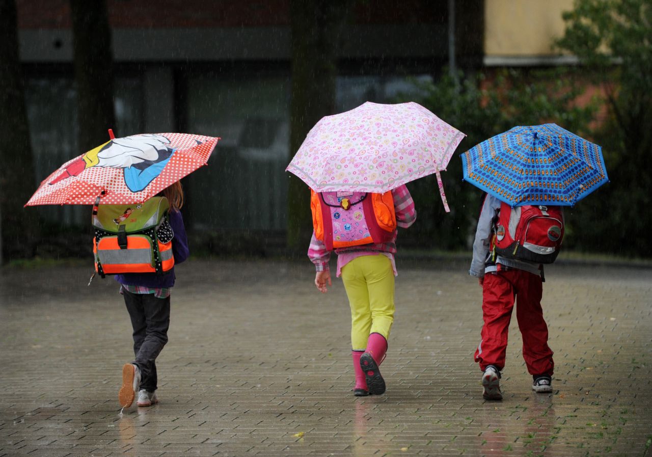 Schoolchildren walk to school in heavy rain in Kassel, Germany, on August 19. 