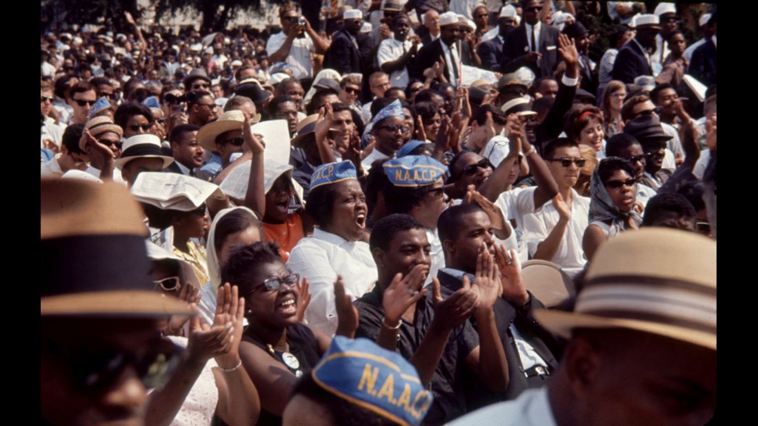 Civil rights protesters clap and cheer. An estimated 250,000 people participated in the march.