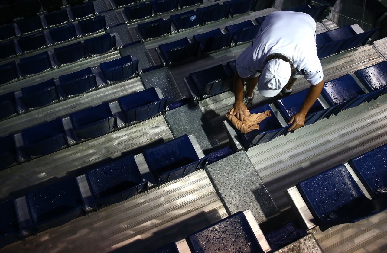 A man dries off seats during a rain delay at the quarterfinal matches of the Winston-Salem Open tennis tournament at Wake Forest University in Winston Salem, North Carolina, on August 22.