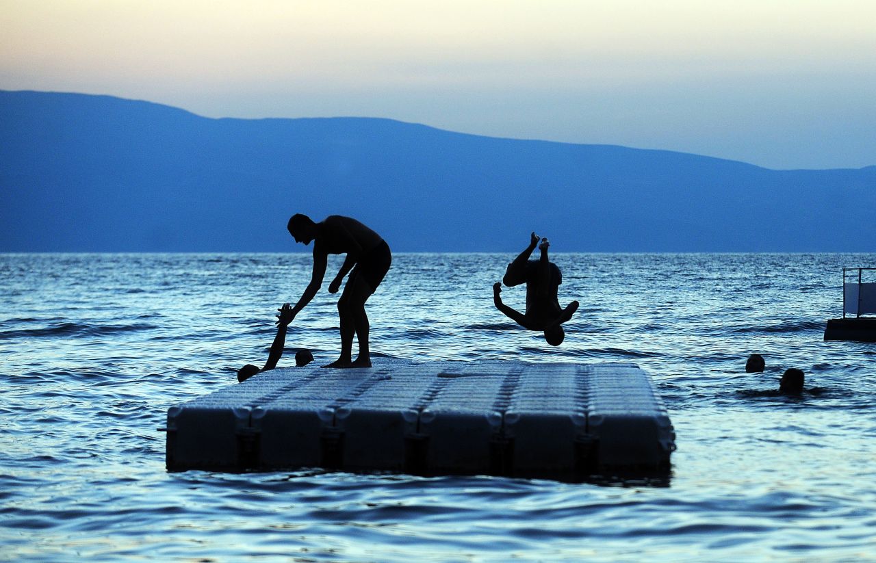 A man jumps in Ohrid Lake in Macedonia at sunset on August 24. Hot and sunny weather in Macedonia sent residents of the Balkan country to nearby rivers and lakes seeking refreshment.