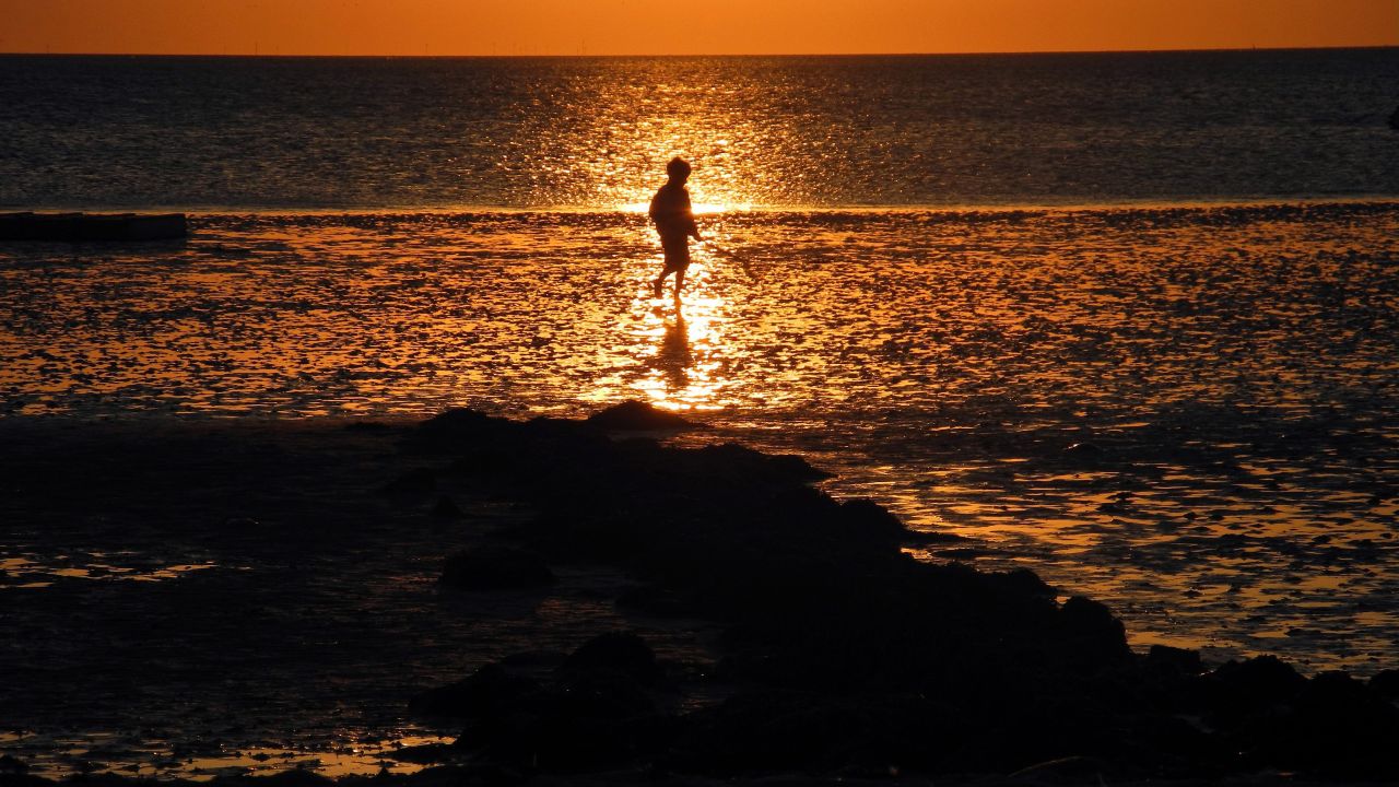 A boy walks along the shore in Utersum on the North Sea island of Foehr, Germany, on Saturday, August 24. Click through to see other images of weather around the world.