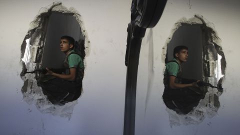 A young Free Syrian Army fighter is reflected in a mirror as he takes position in a house in Aleppo on Thursday, August 22.