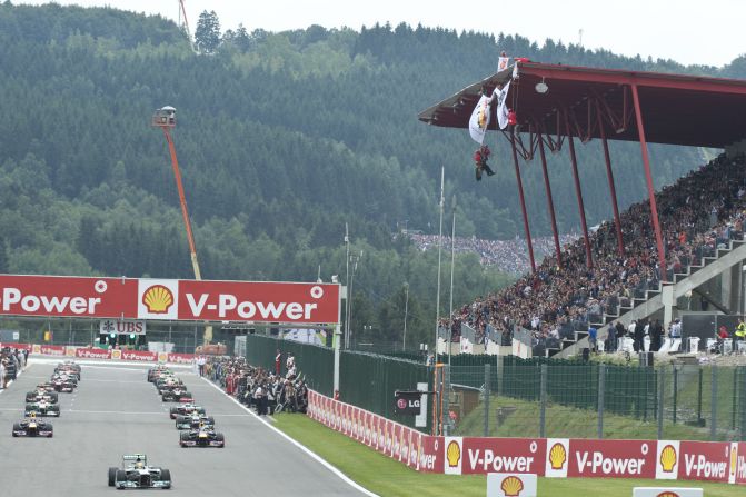 Drivers perform a warm-up lap at the Spa-Francorchamps circuit as Greenpeace militants deploy a banner reading "ARCTIC OIL? SHELL NO!"