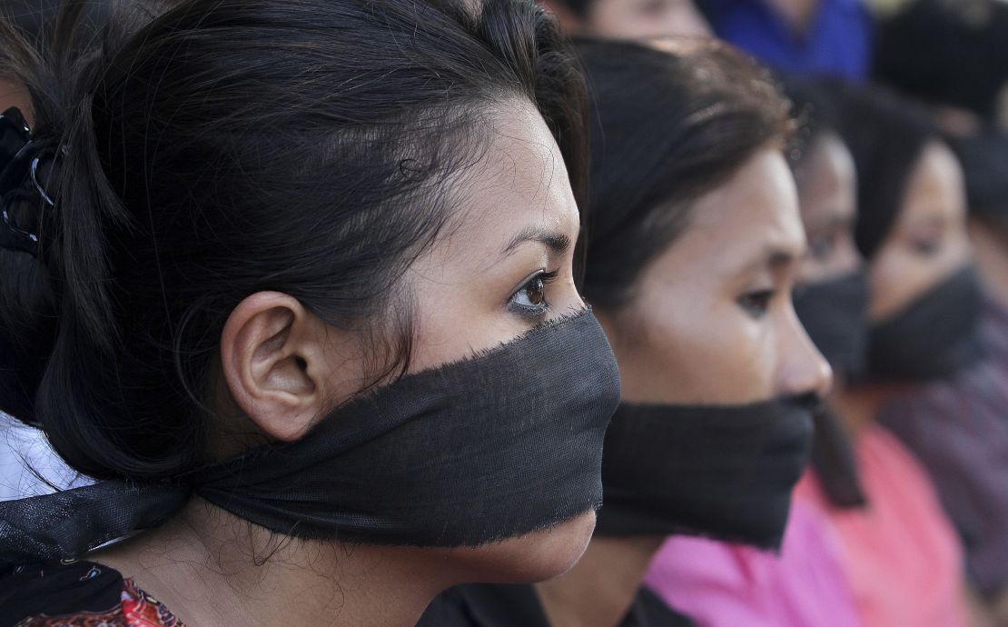 Women cover their mouths in a 2013 protest against rape in Guwahati, India. 