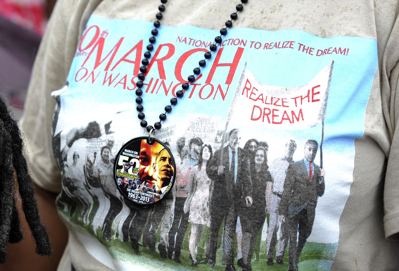 A woman wearing a T-shirt commemorating the anniversary stands at the Lincoln Memorial in Washington.