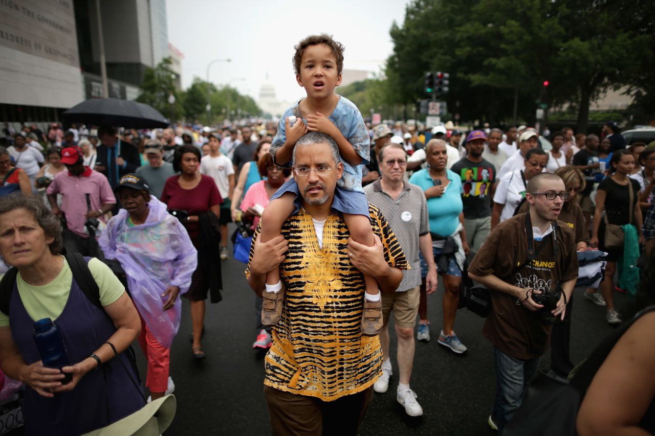 John Mbugua and his son Giovanni, of San Jose, California, march with thousands of other people from Capitol Hill to the Lincoln Memorial, honoring the 50th anniversary of the March on Washington on August 28.