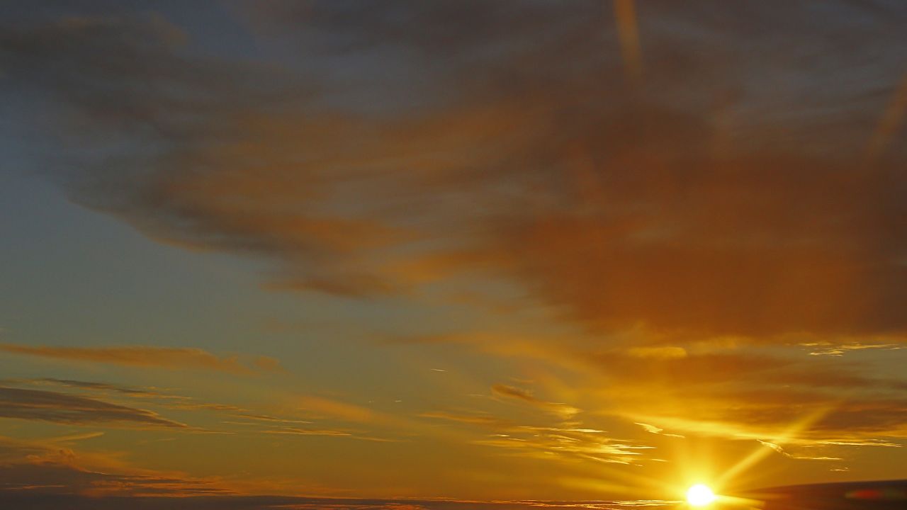Clouds are seen as the sun set behind the horizon in the sky from an airplane near Vienna on October 10, 2012
