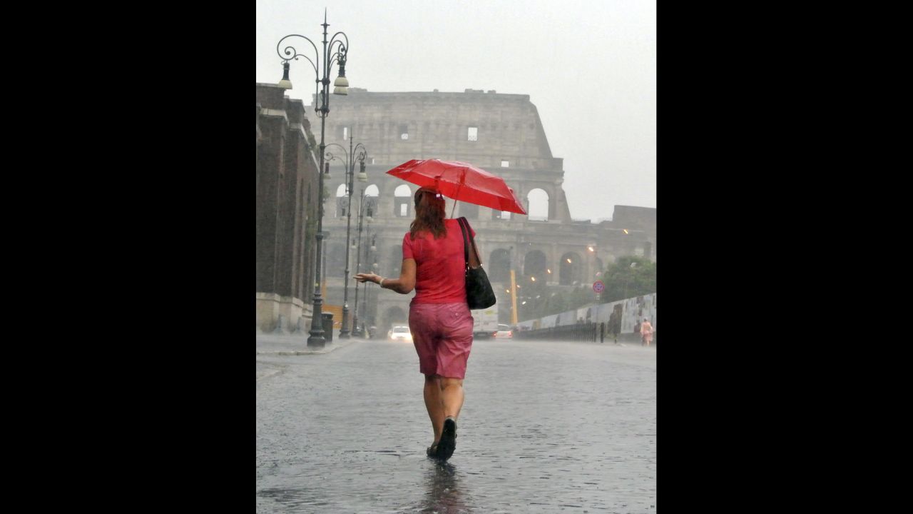 A woman strolls along Via dei Fori Imperiali toward the Colosseum in Rome on August 27.