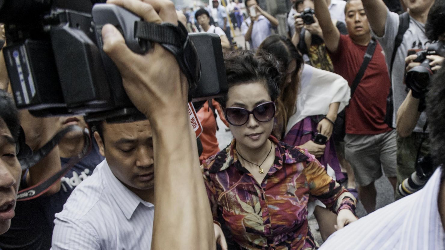 Famed Chinese military singer Meng Ge makes her way to the Beijing courthouse where her teen son faces rape charges.