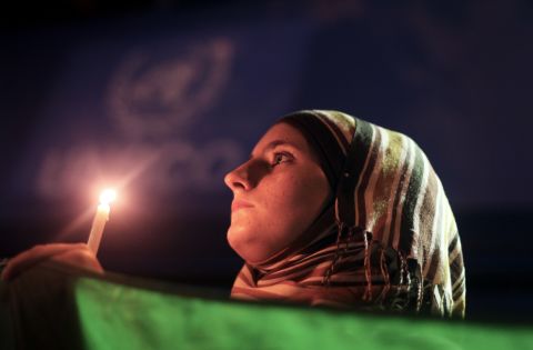 A young woman holds a Syrian revolution flag and a candle during a protest of President Bashar al-Assad in front of the U.N. headquarters in Gaza City on Friday, August 23. U.N. Secretary-General Ban Ki-moon intends to conduct a "thorough, impartial and prompt investigation" into the alleged chemical weapons attack in Syria.