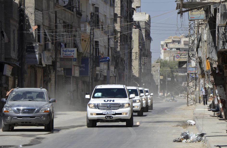 Free Syrian Army fighters escort U.N. vehicles with chemical weapons experts on August 28 through a site of a suspected chemical weapons attack outside Damascus. 