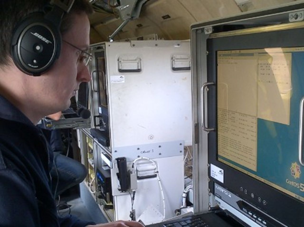 A flight test engineer monitors a computer display screen