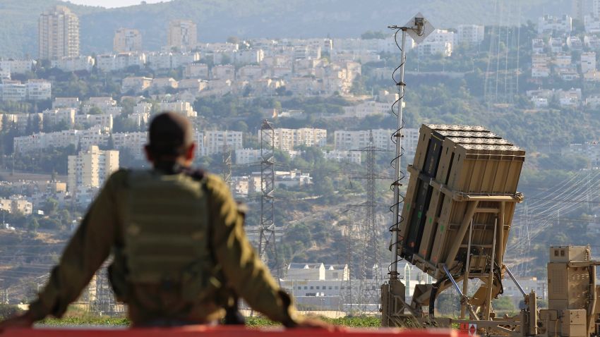 An Israeli soldier is seen next to an Iron Dome rocket interceptor battery deployed near the northern Israeli city of Haifa, Wednesday, Aug. 28, 2013. Israel ordered a special call-up of reserve troops Wednesday as nervous citizens lined up at gas-mask distribution centers, preparing for possible hostilities with Syria. (AP Photo/Tsafrir Abayov)