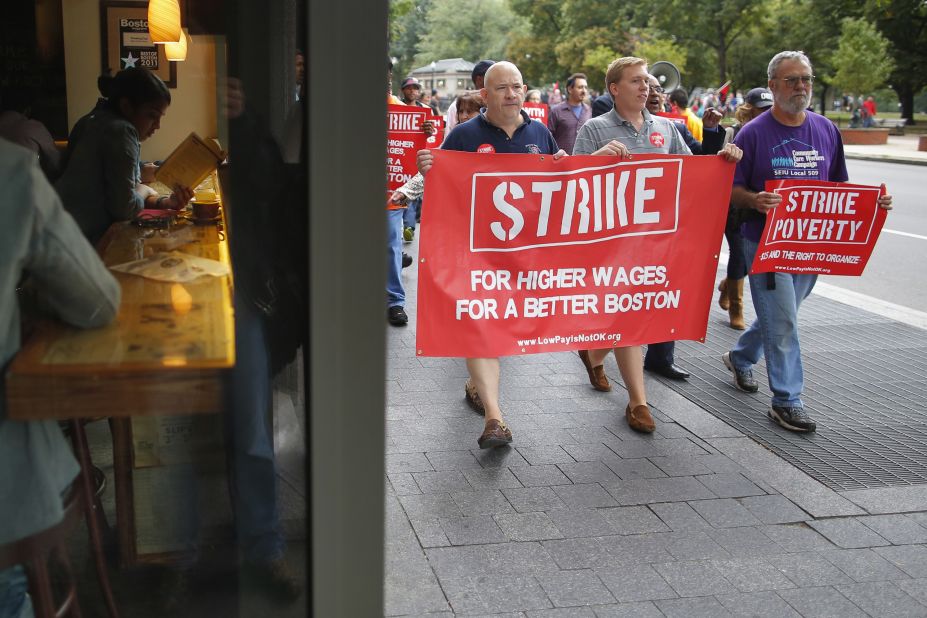 Demonstrators pass a cafe during a march through the streets of Boston on August 29.